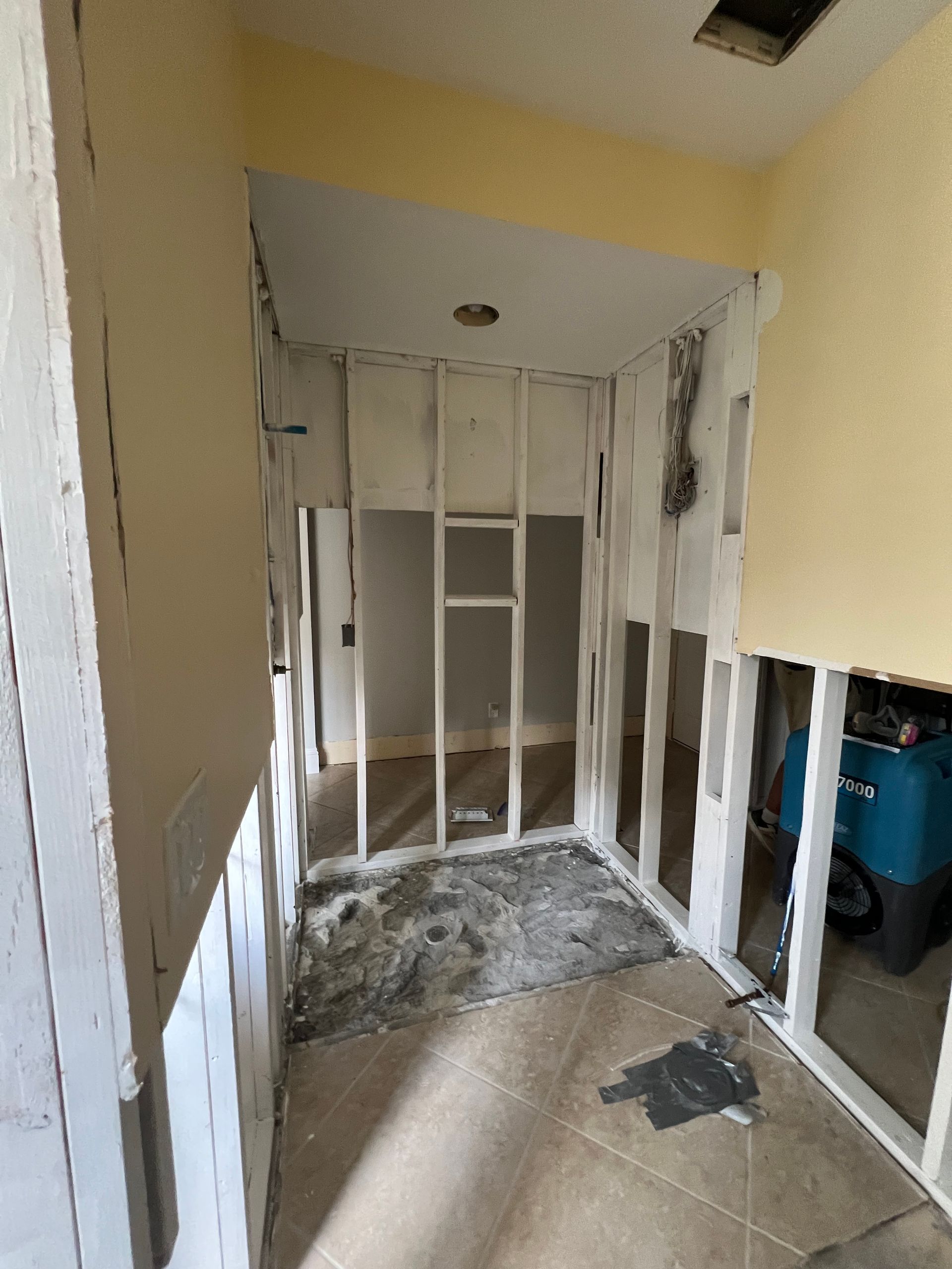 A room with a lot of walls and a vacuum cleaner in it.