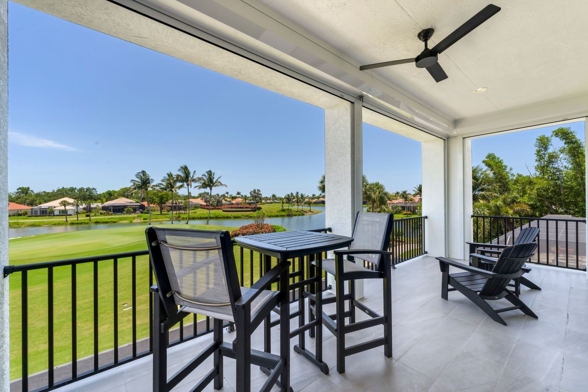 A balcony with a table and chairs and a ceiling fan