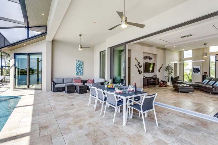 A large house with a dining table and chairs and a ceiling fan.