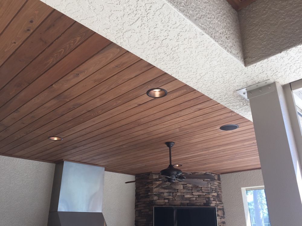 A room with a wooden ceiling and a ceiling fan