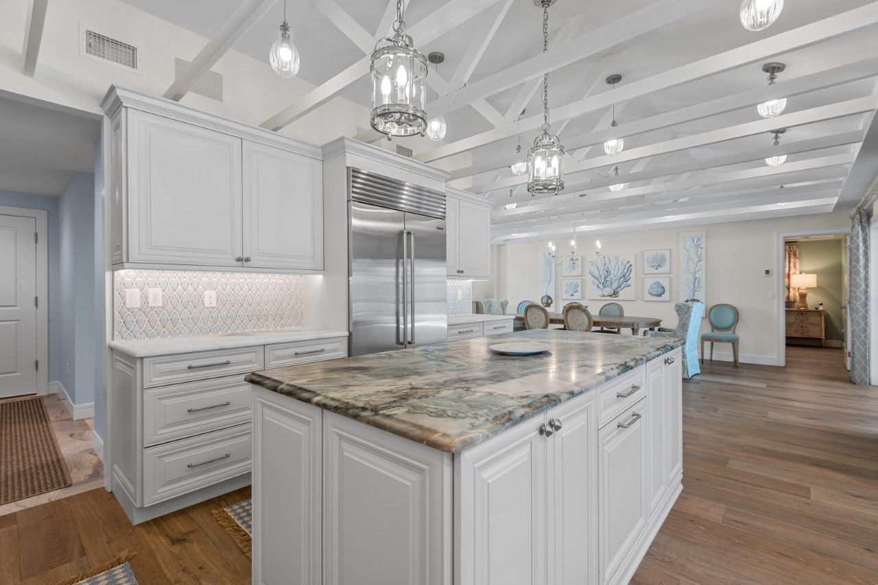 A kitchen with white cabinets , granite counter tops , and stainless steel appliances.