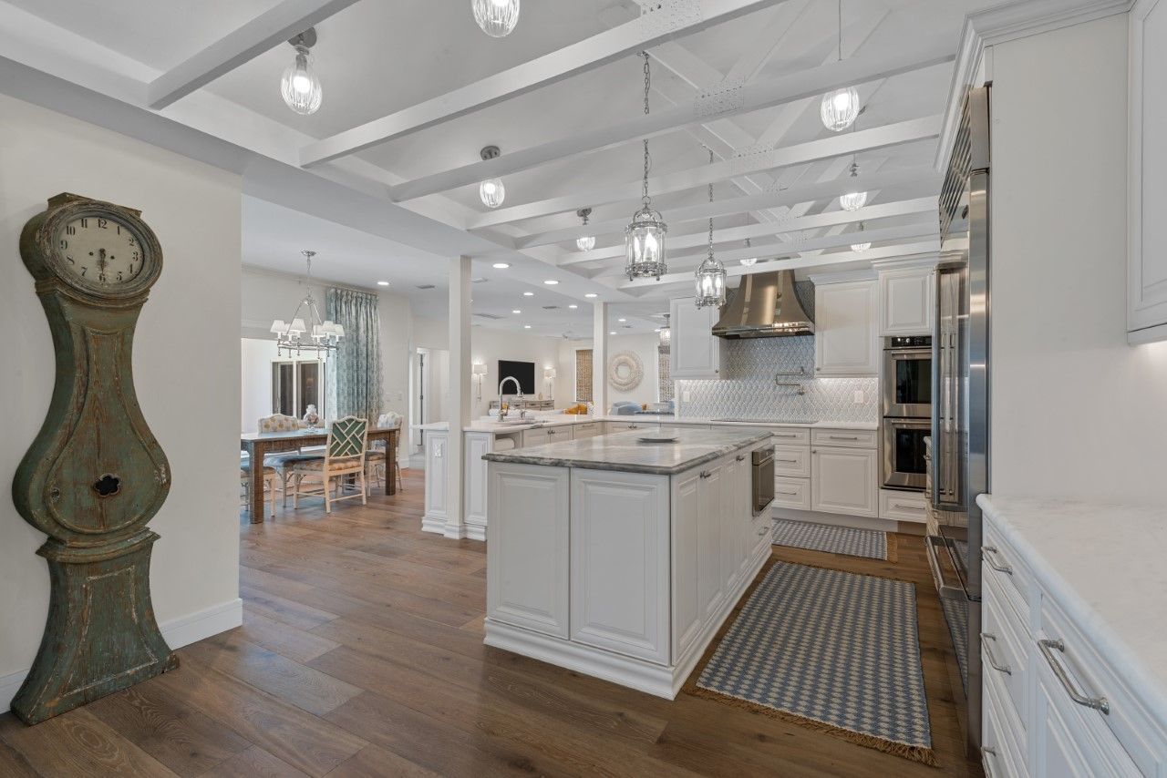 A kitchen with a large island and a clock on the wall.