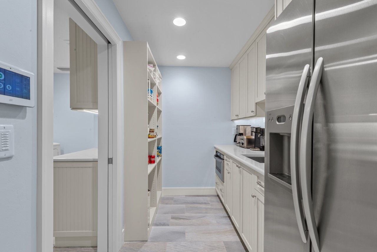 A kitchen with stainless steel appliances and white cabinets.