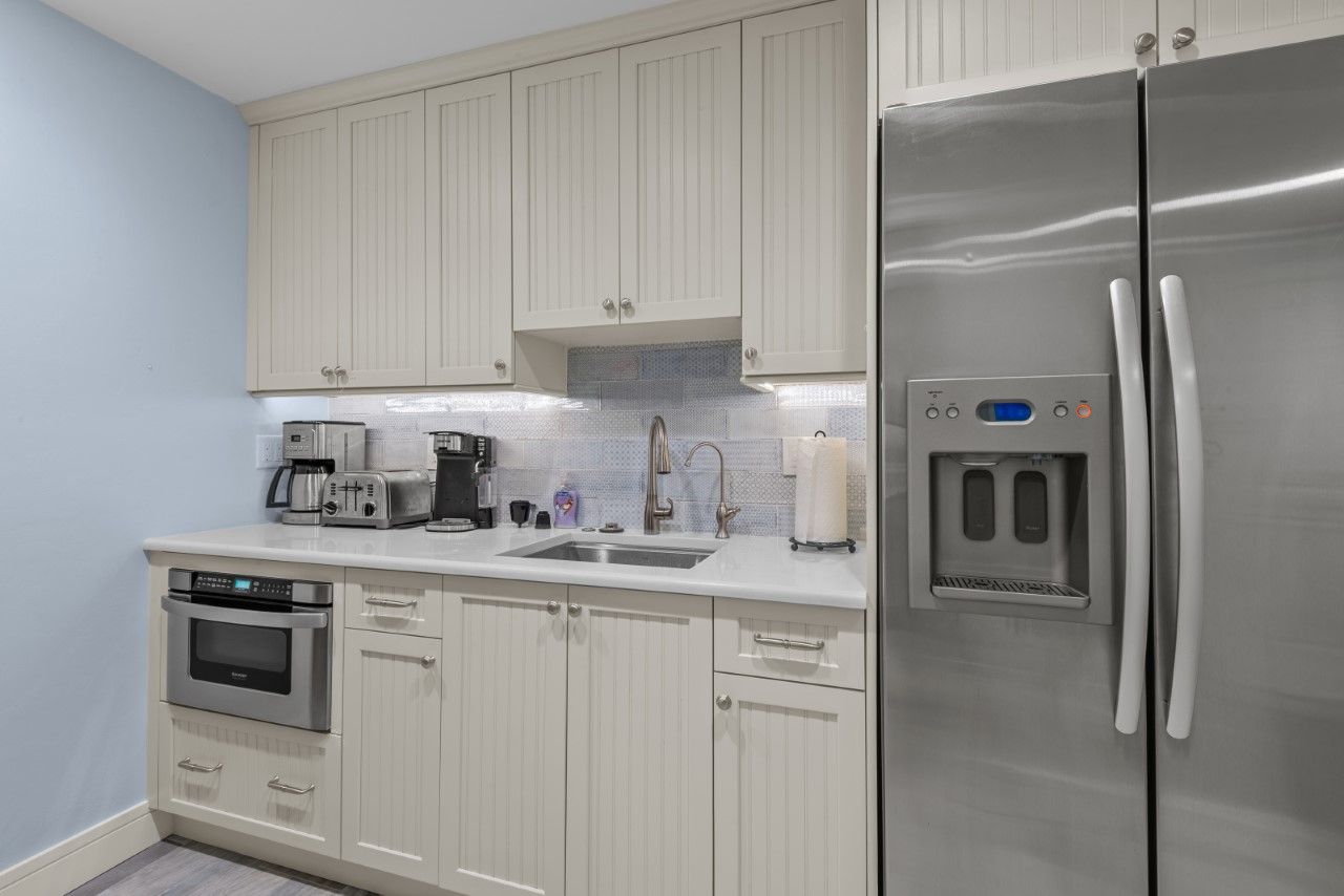 A kitchen with stainless steel appliances and white cabinets.