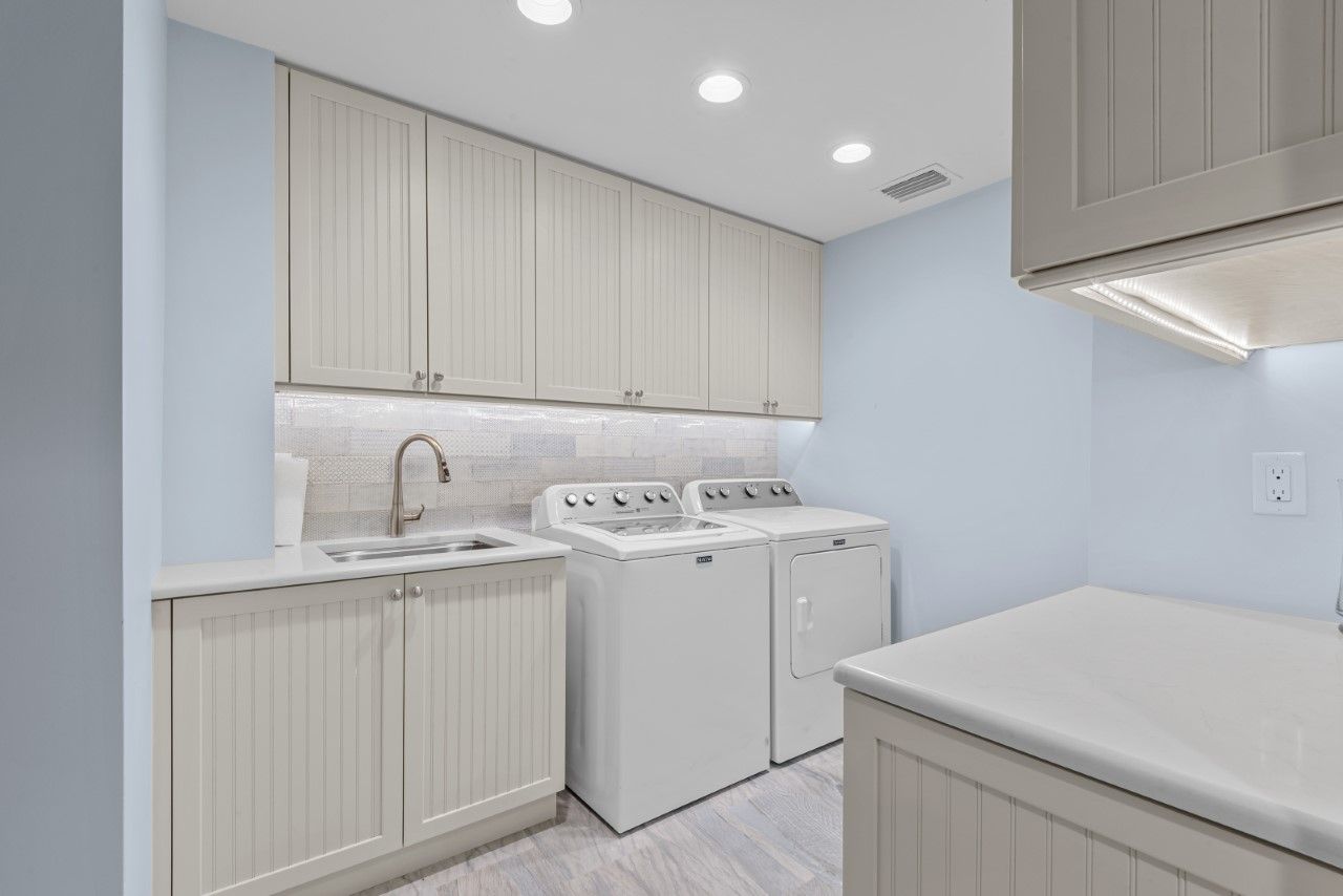 A laundry room with a washer and dryer and a sink.