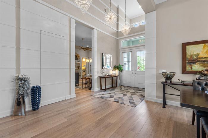 A large hallway with hardwood floors and a painting on the wall.