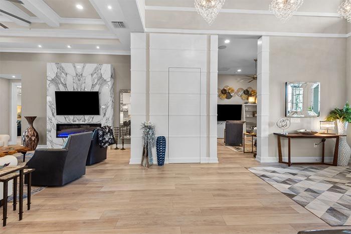 A living room with hardwood floors and a flat screen tv on the wall.
