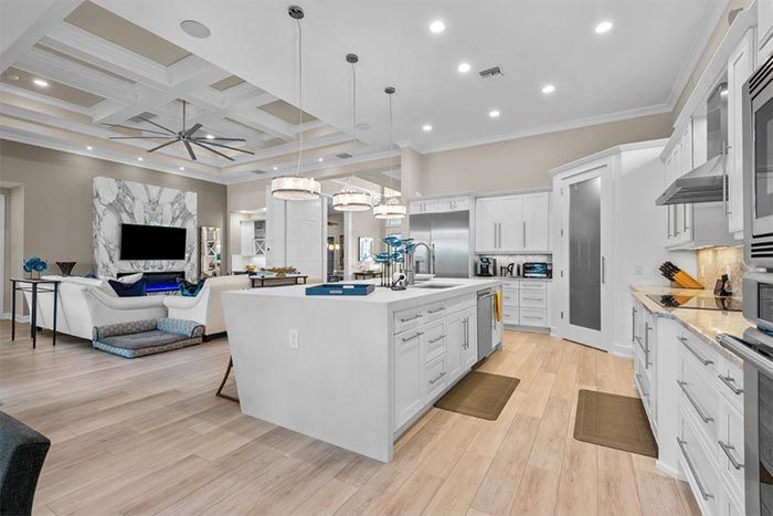 A kitchen in a house with white cabinets and stainless steel appliances.