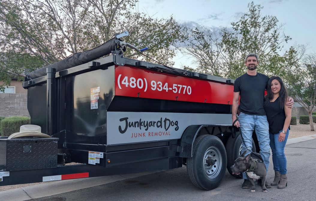 A man is standing in front of a pile of garbage.