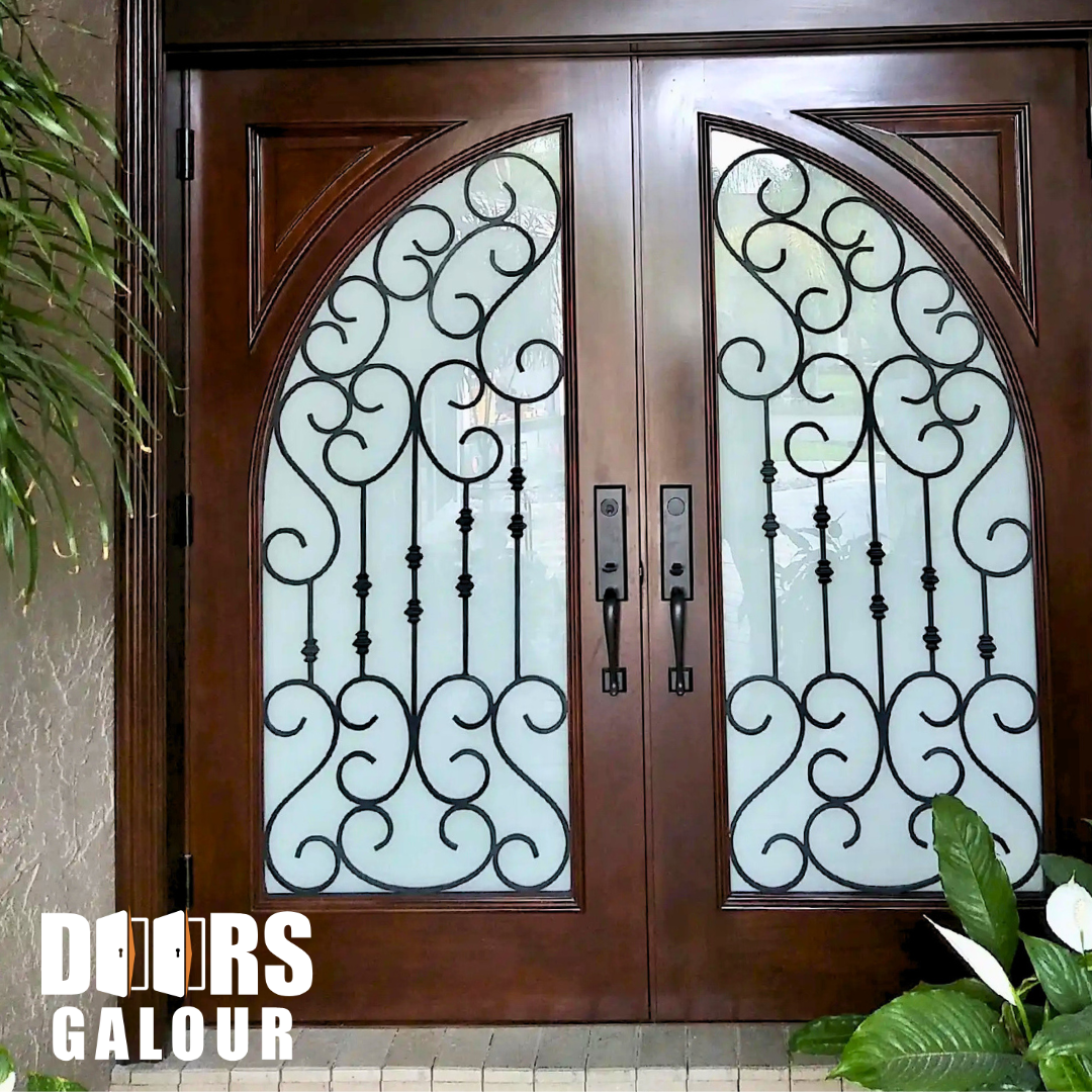 Double wooden front doors with arched glass panels and decorative ironwork.