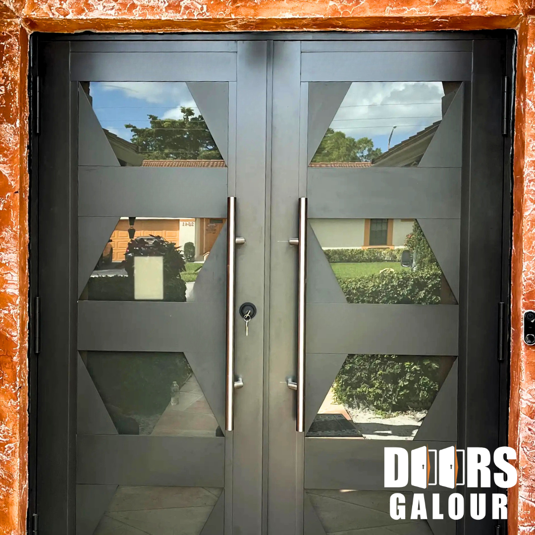 Double metal door with geometric glass panels, chrome handles, and a rustic orange frame.
