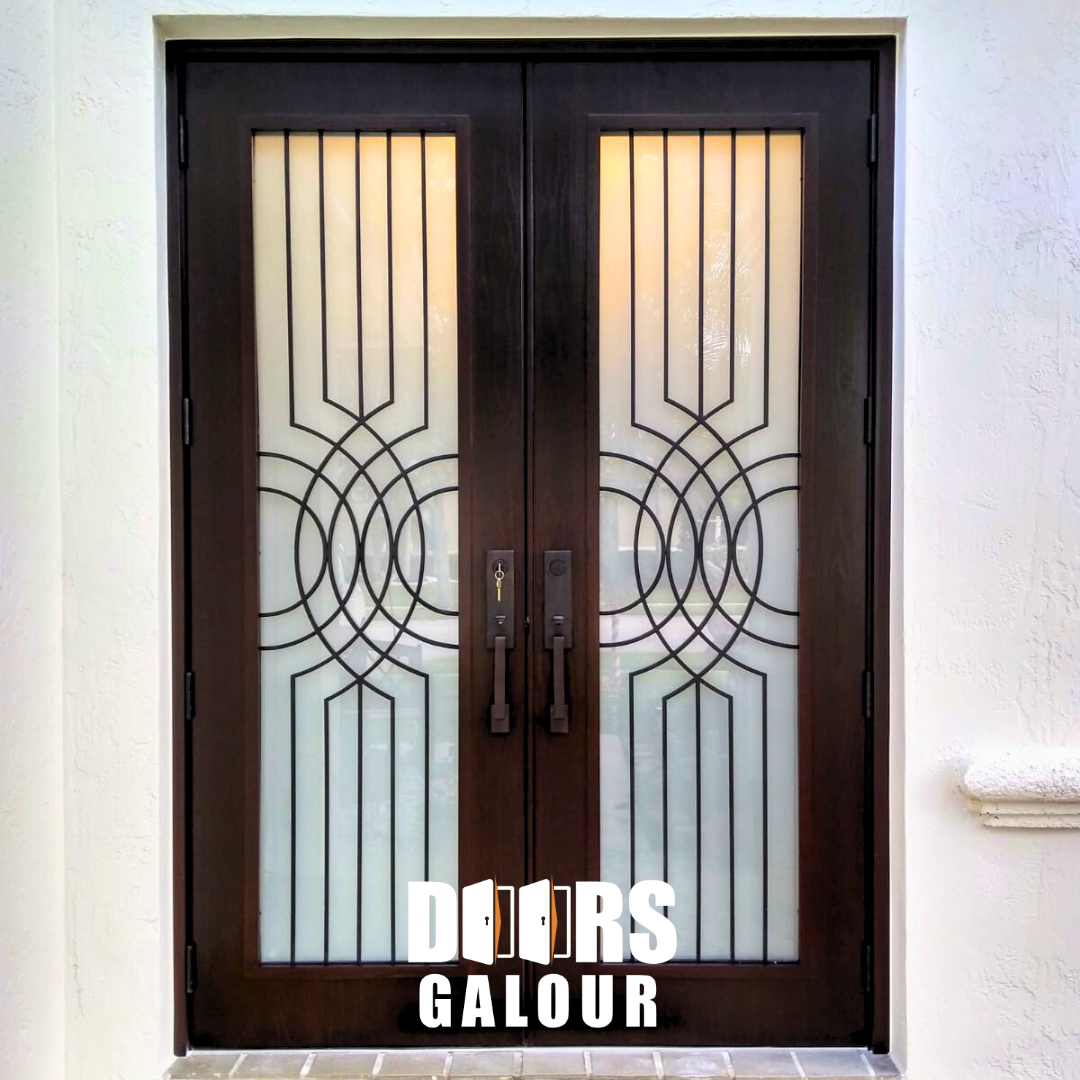 Dark double doors with decorative black metalwork and frosted glass panels; white exterior.