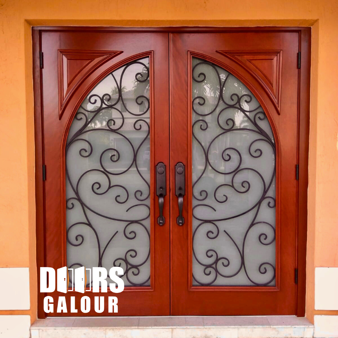 Double wooden doors with iron scrollwork and frosted glass, set in an orange building.