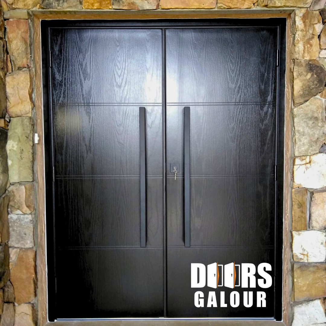 Black double doors with long handles set in stone, bearing the 