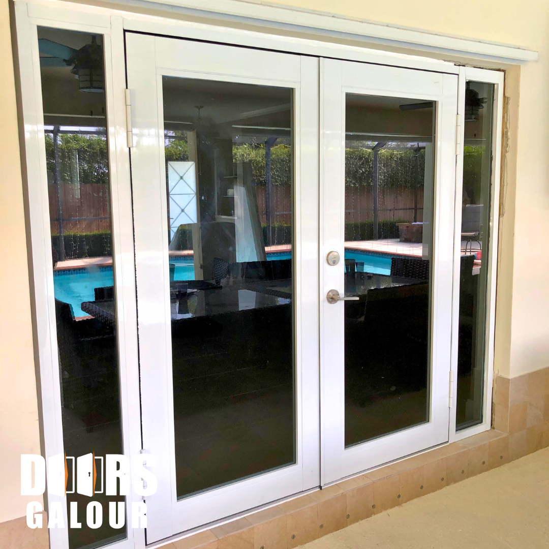 White French doors with sidelights overlooking a pool.