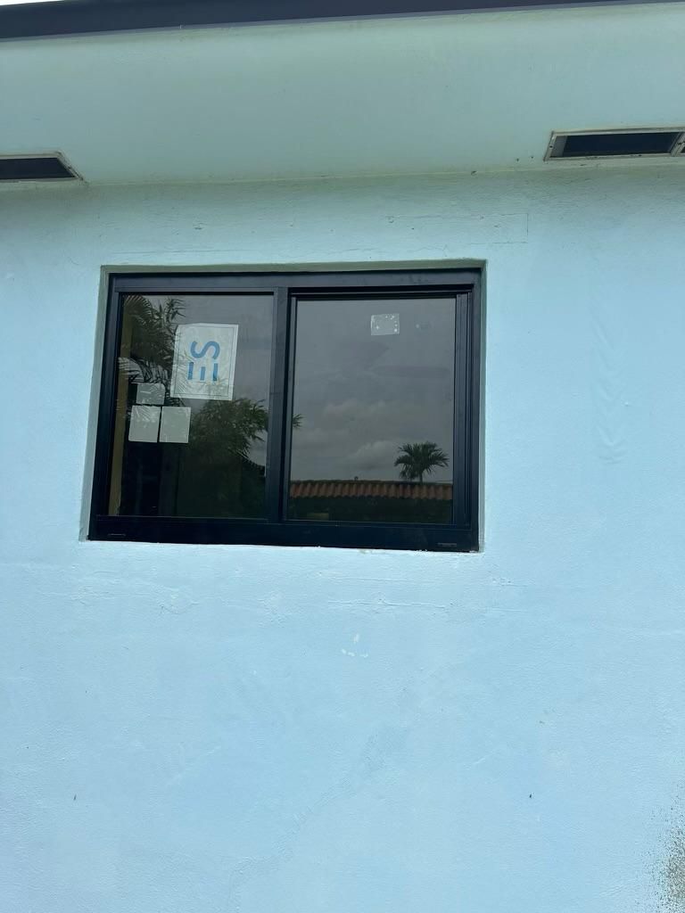 A stylish Sliding Impact Window near a lamp in South Florida