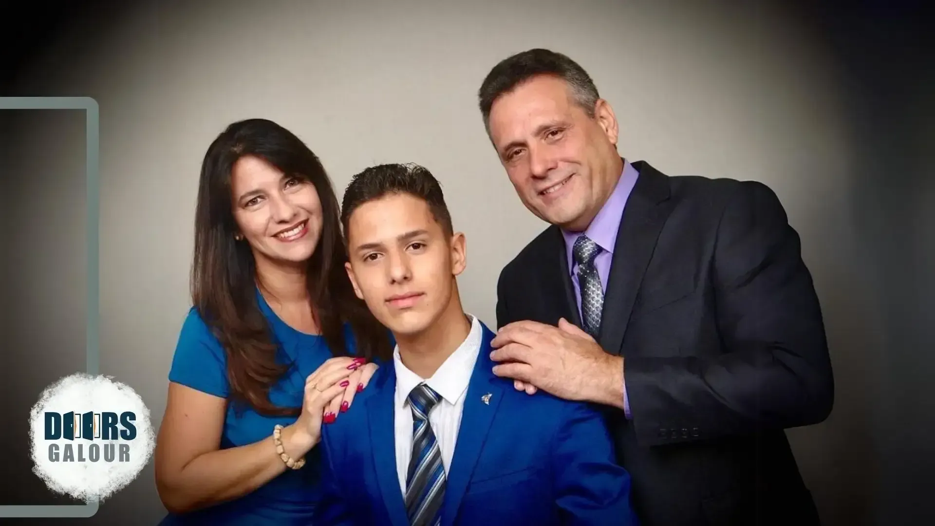 A man in a suit and tie is posing for a picture with his parents.