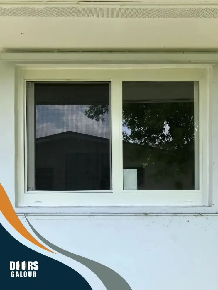 A white window with a reflection of trees in it