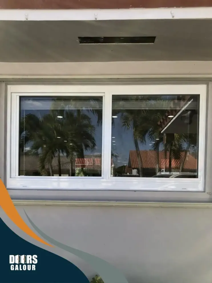 A white window with a reflection of palm trees in it