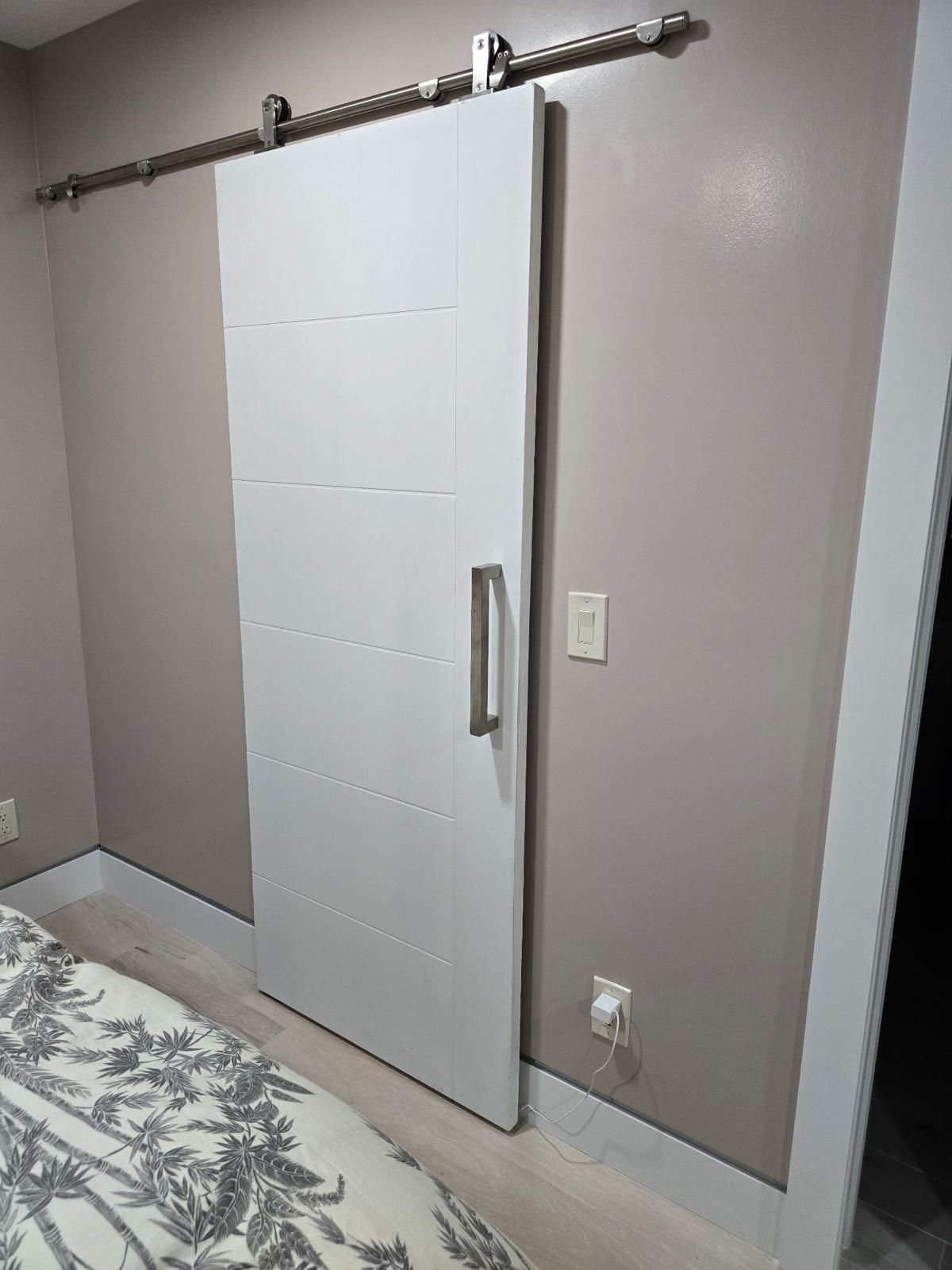 Two white doors in a hallway; one closed, one slightly ajar.