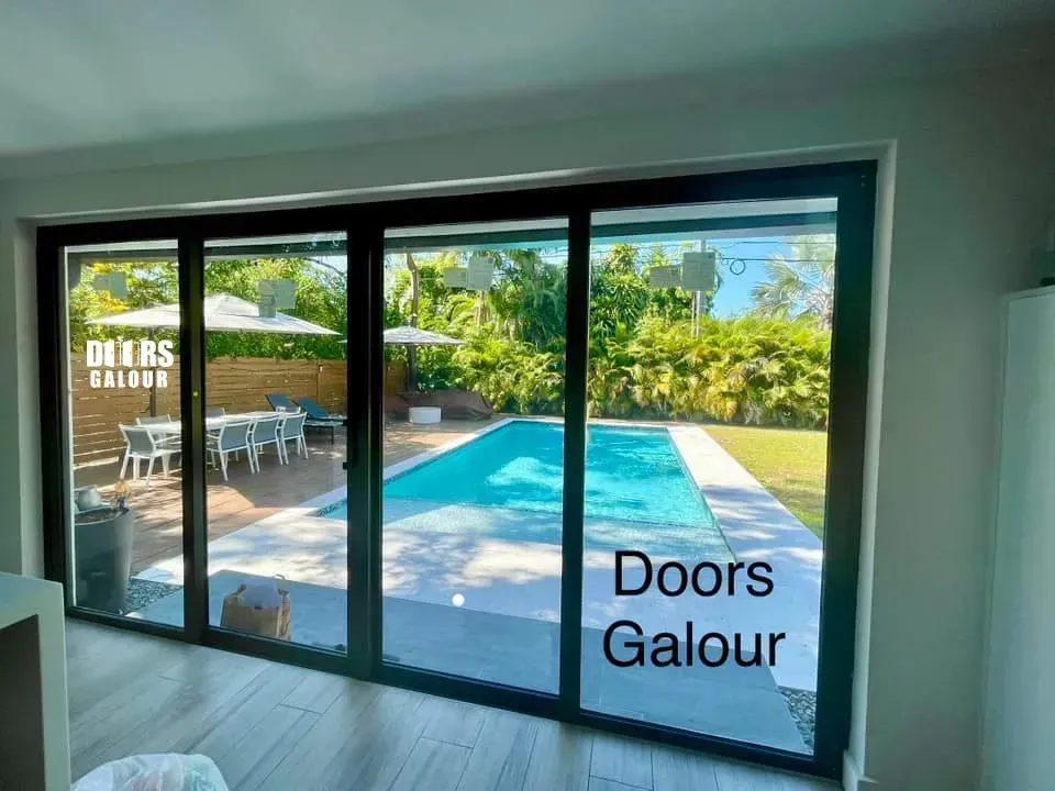 Sliding glass doors open to a pool and backyard dining area. The scene is bright with sunlight.