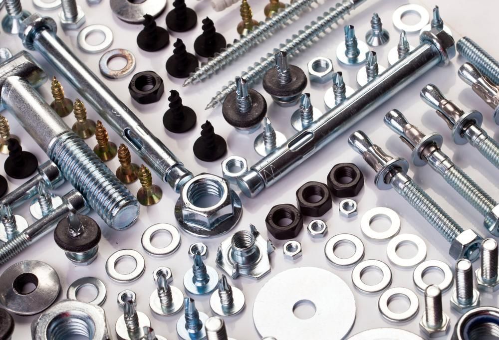 A Bunch Of Nuts And Bolts On A White Surface — Illawarra Fasteners Pty Ltd In Unanderra, NSW