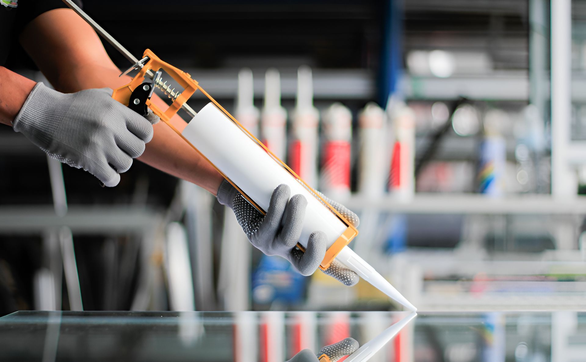A Man Is Applying Sealant — Illawarra Fasteners Pty Ltd In Unanderra, NSW