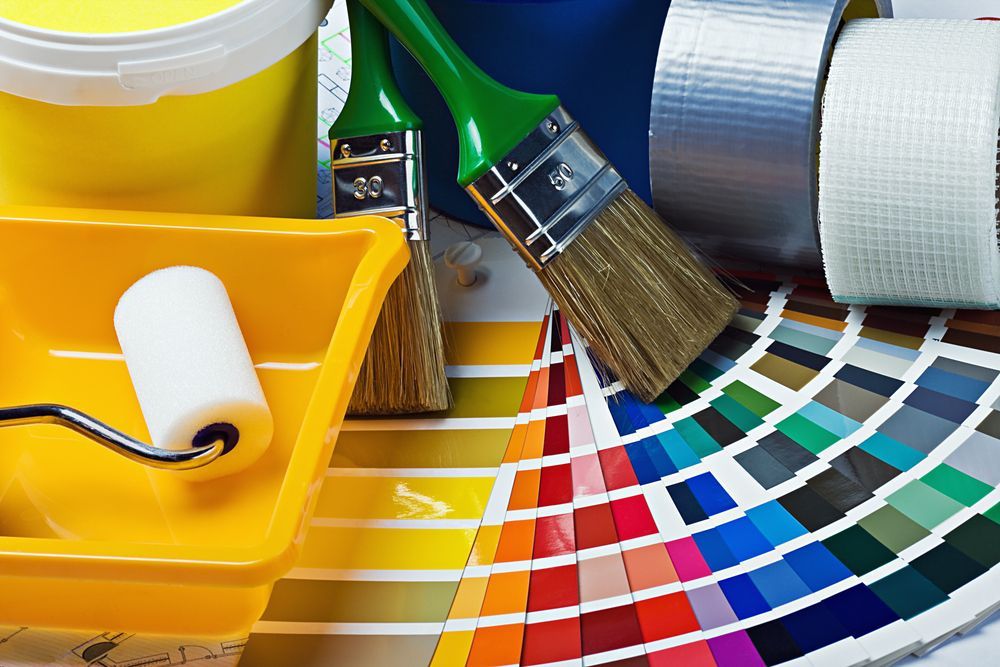 A Bucket Of Paint, Brushes, Tape, And A Roller Are On A Table — Illawarra Fasteners Pty Ltd In Unanderra, NSW