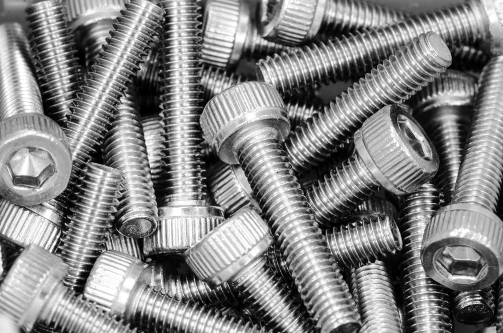 A Pile Of Stainless Steel Screws And Bolts On A Table — Illawarra Fasteners Pty Ltd In Unanderra, NSW
