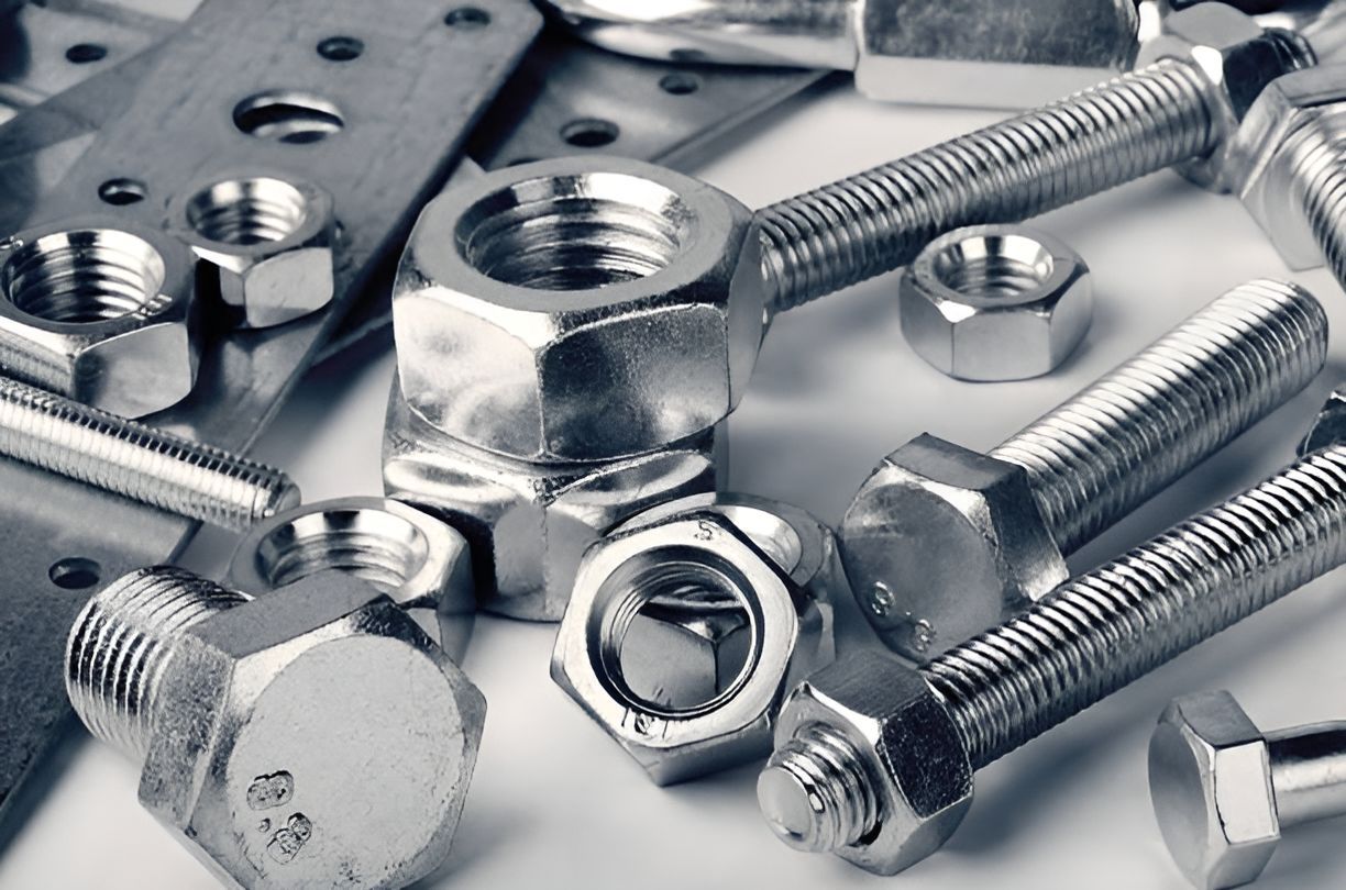 A Bunch Of Nuts And Bolts On A White Surface — Illawarra Fasteners Pty Ltd In Unanderra, NSW