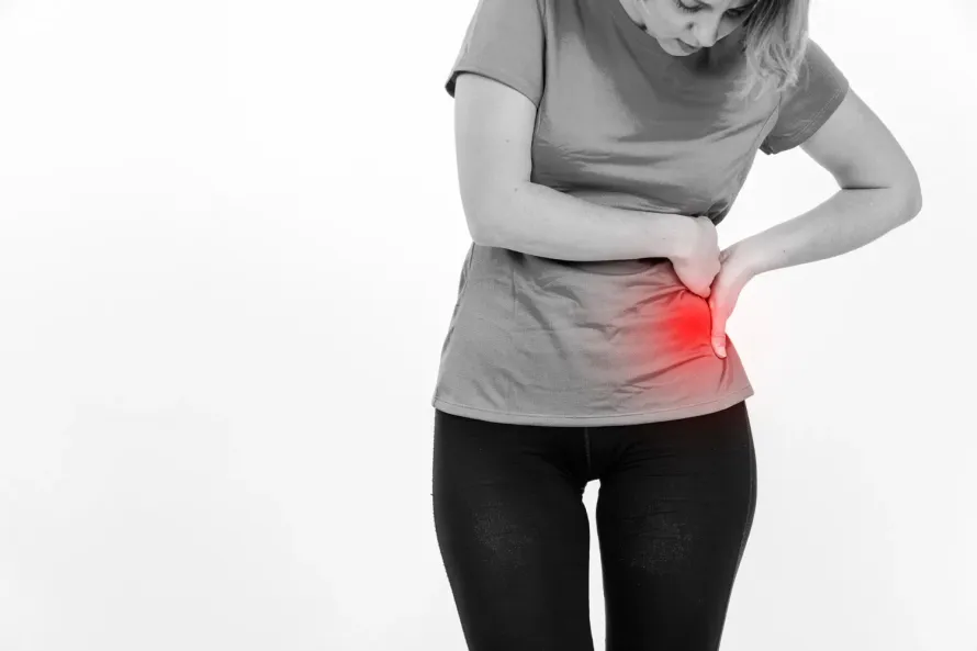Une femme se tient le ventre de douleur.