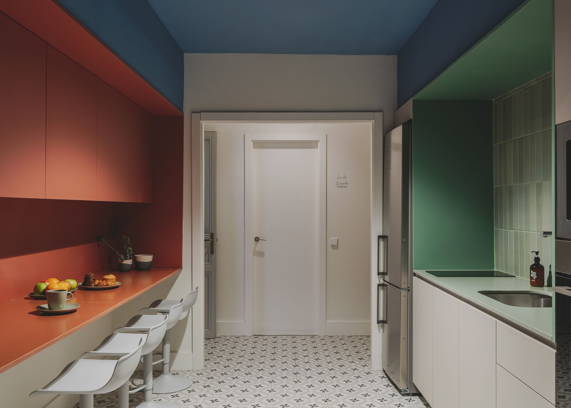 A kitchen with a blue ceiling and red and green walls