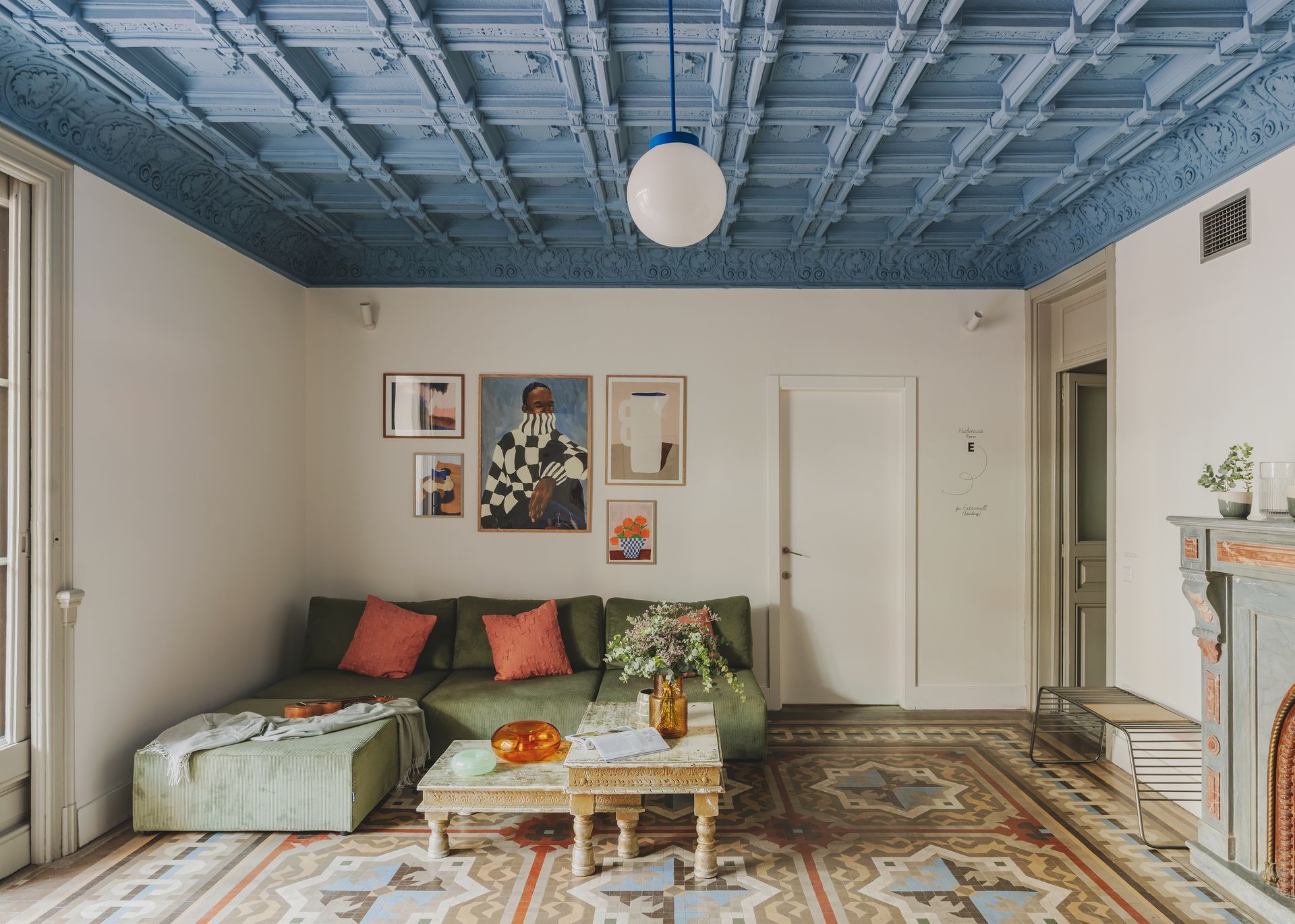 A living room with a blue ceiling and a green couch.