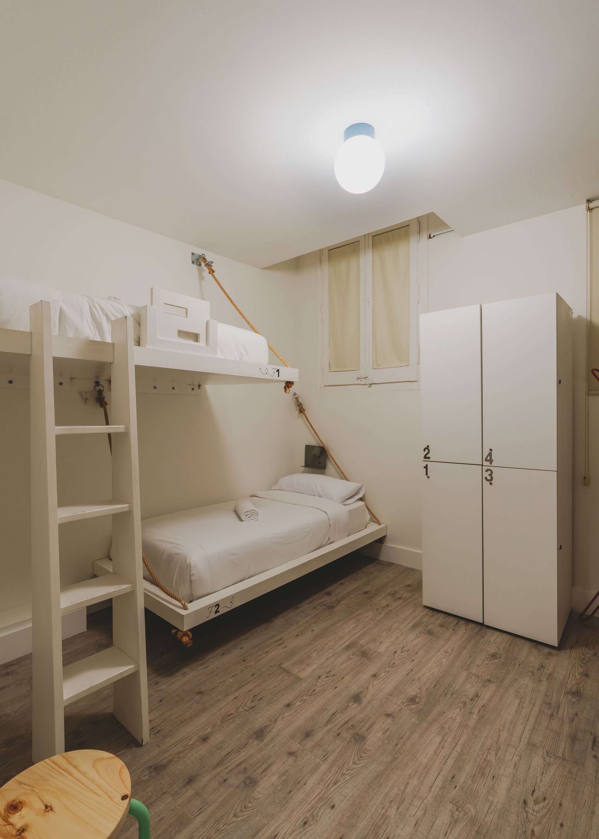 A bedroom with a bunk bed and a ladder.
