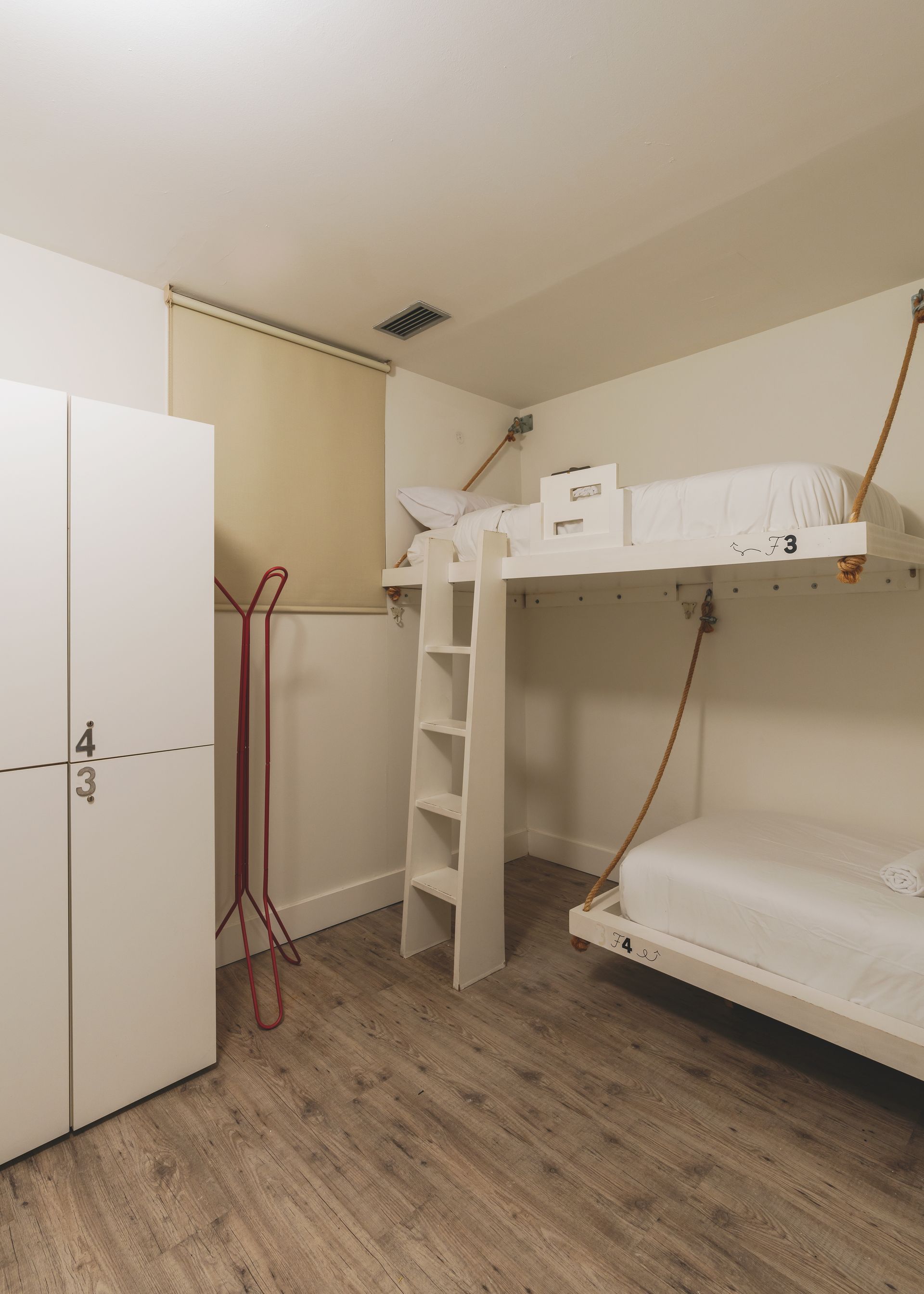 A bedroom with two bunk beds and a ladder.