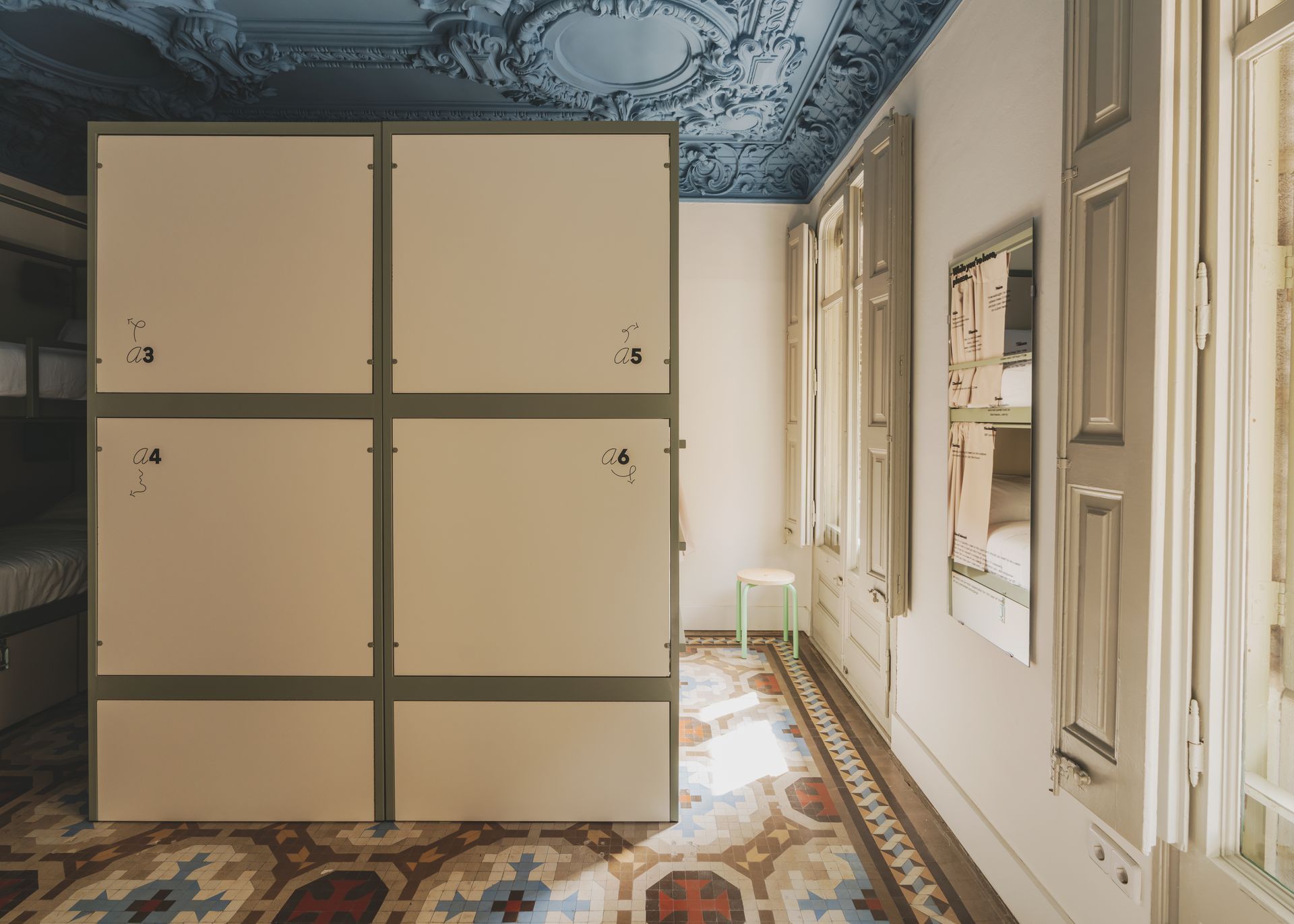 A room with bunk beds and lockers and a blue ceiling.