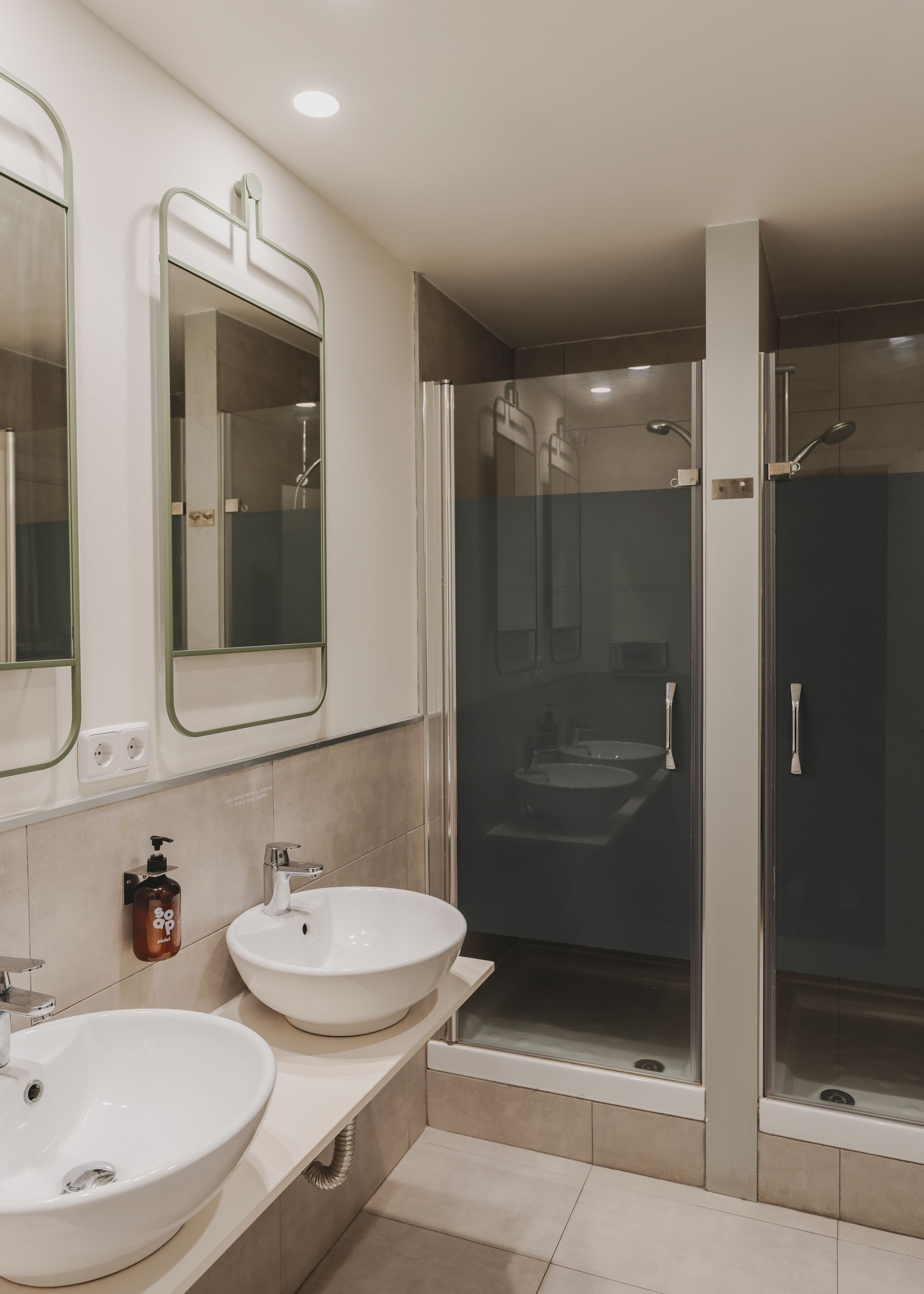 A bathroom with two sinks and a walk in shower