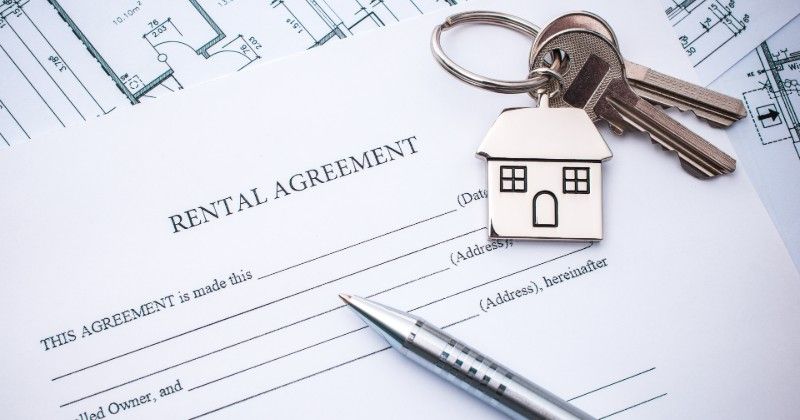 A rental agreement with keys and a pen on it