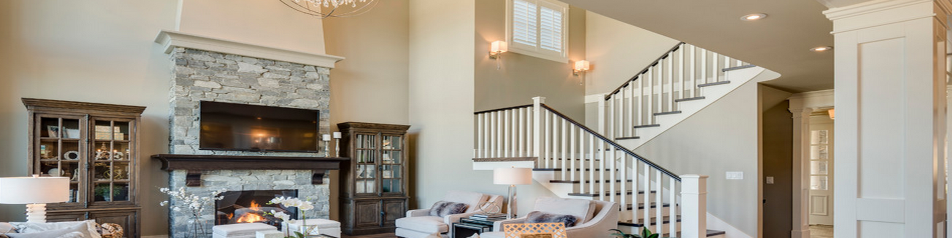 Bright living room with a fireplace, staircase, and neutral furnishings in a modern home