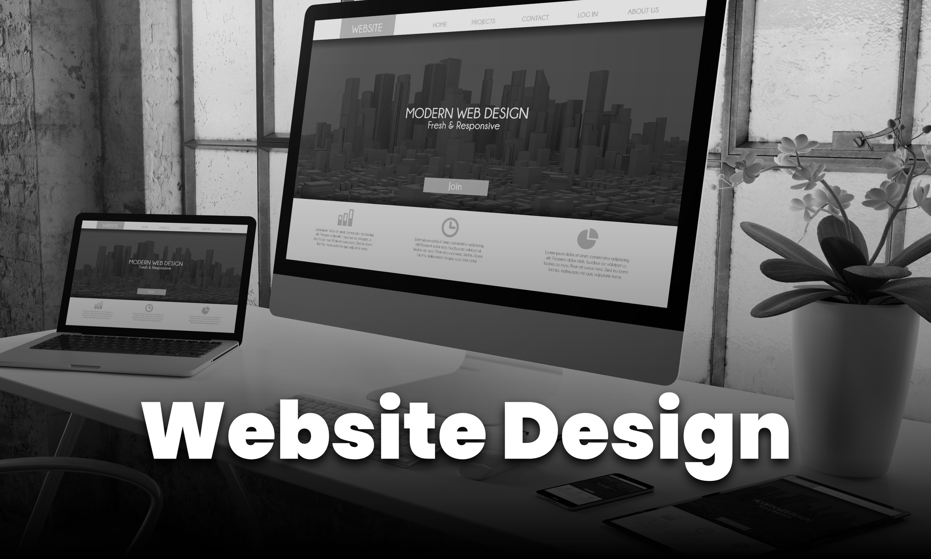 A computer and laptop displaying a website design, with the words 