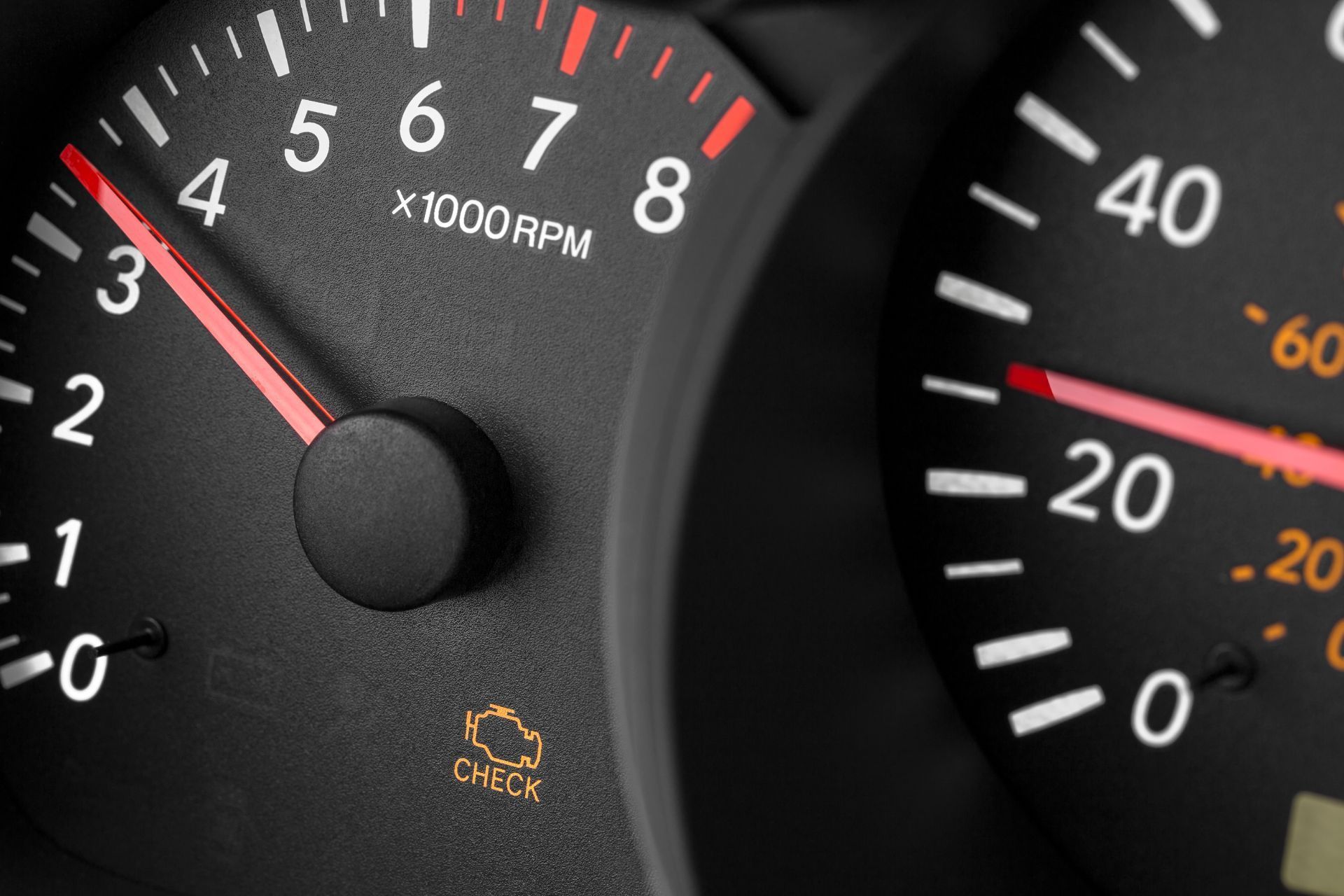 A close up of a car dashboard with a check light on