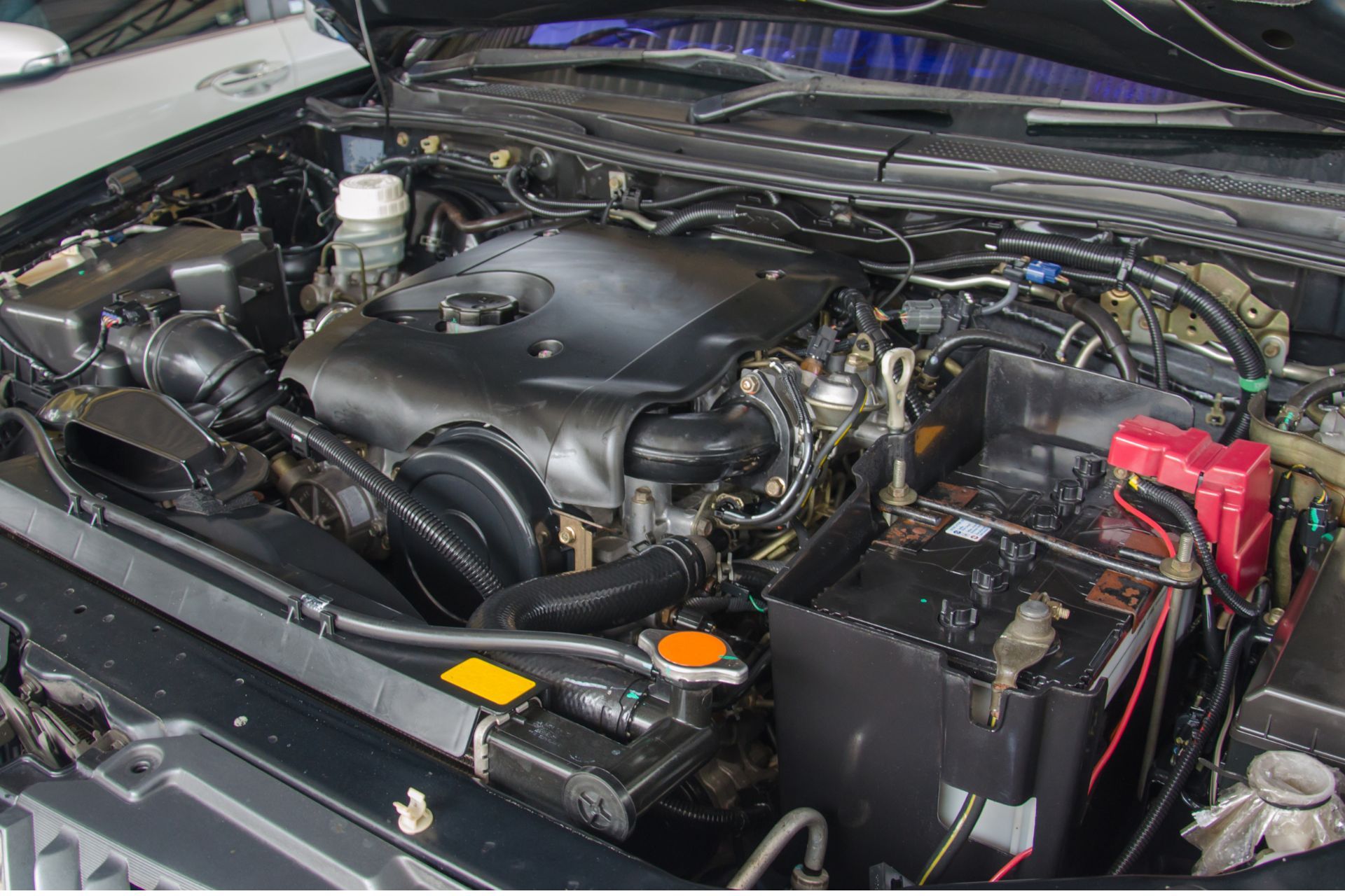 A close up of a car engine with the hood open