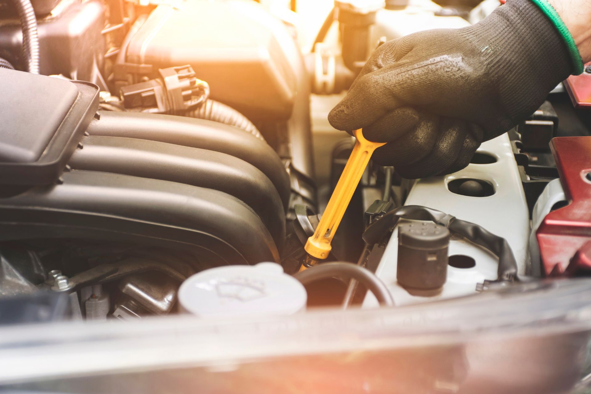 A person is checking the oil in a car with a wrench.