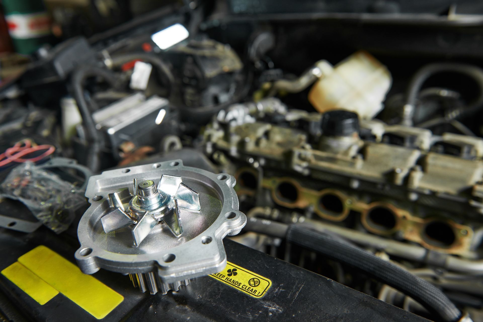 A water pump is sitting on top of a car engine.