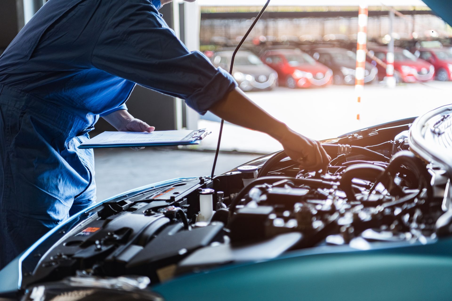 A mechanic is working on the engine of a car in a garage.