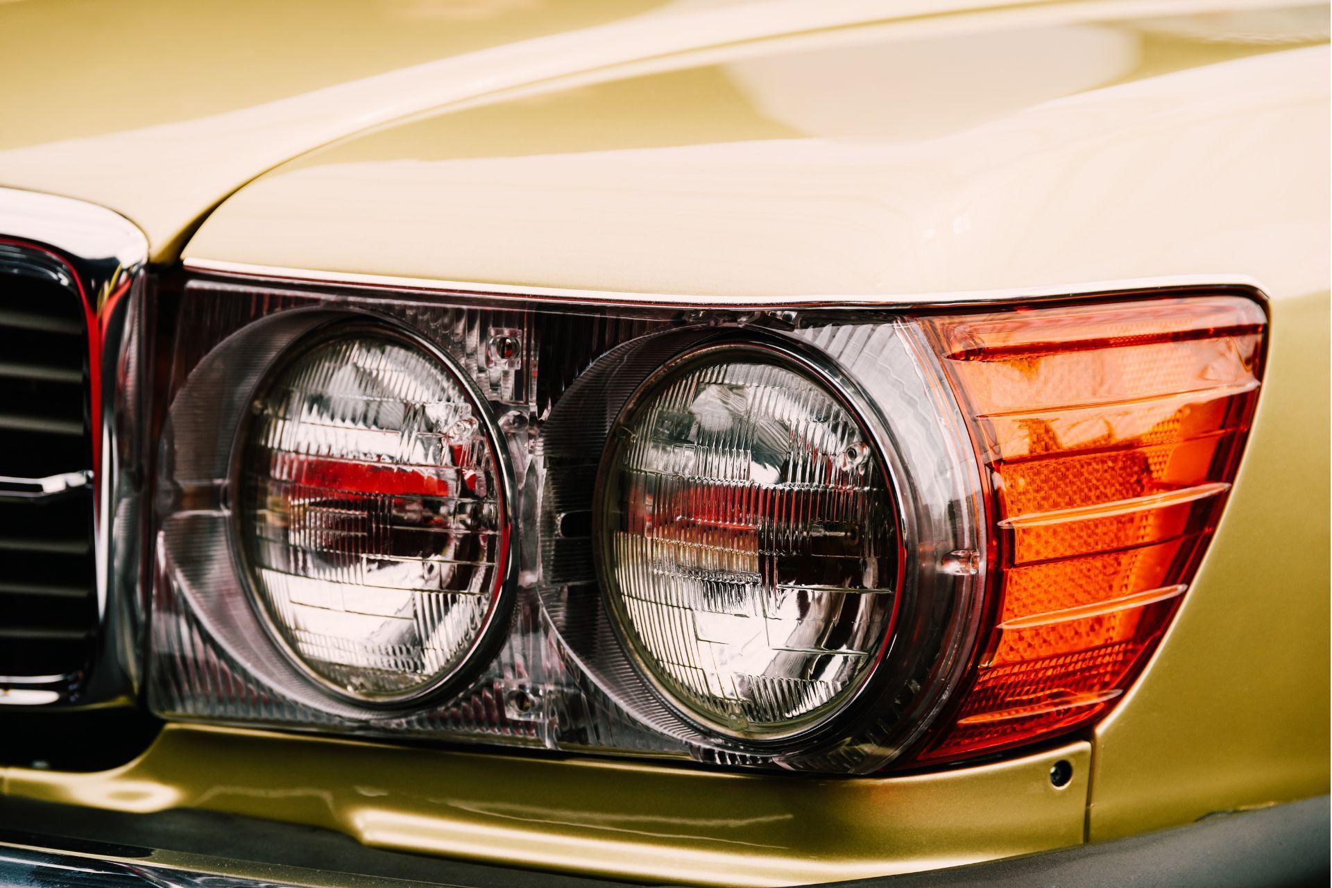 A close up of the headlights of a yellow car.