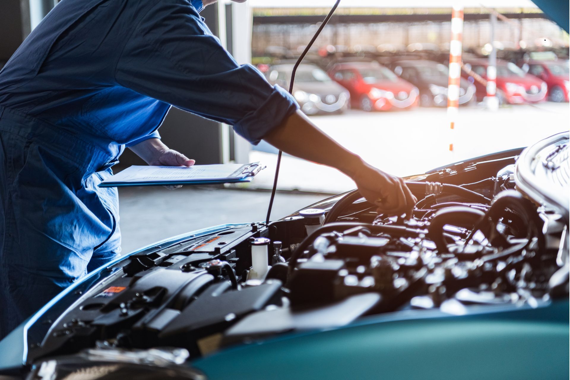 A mechanic is working on the engine of a car in a garage.