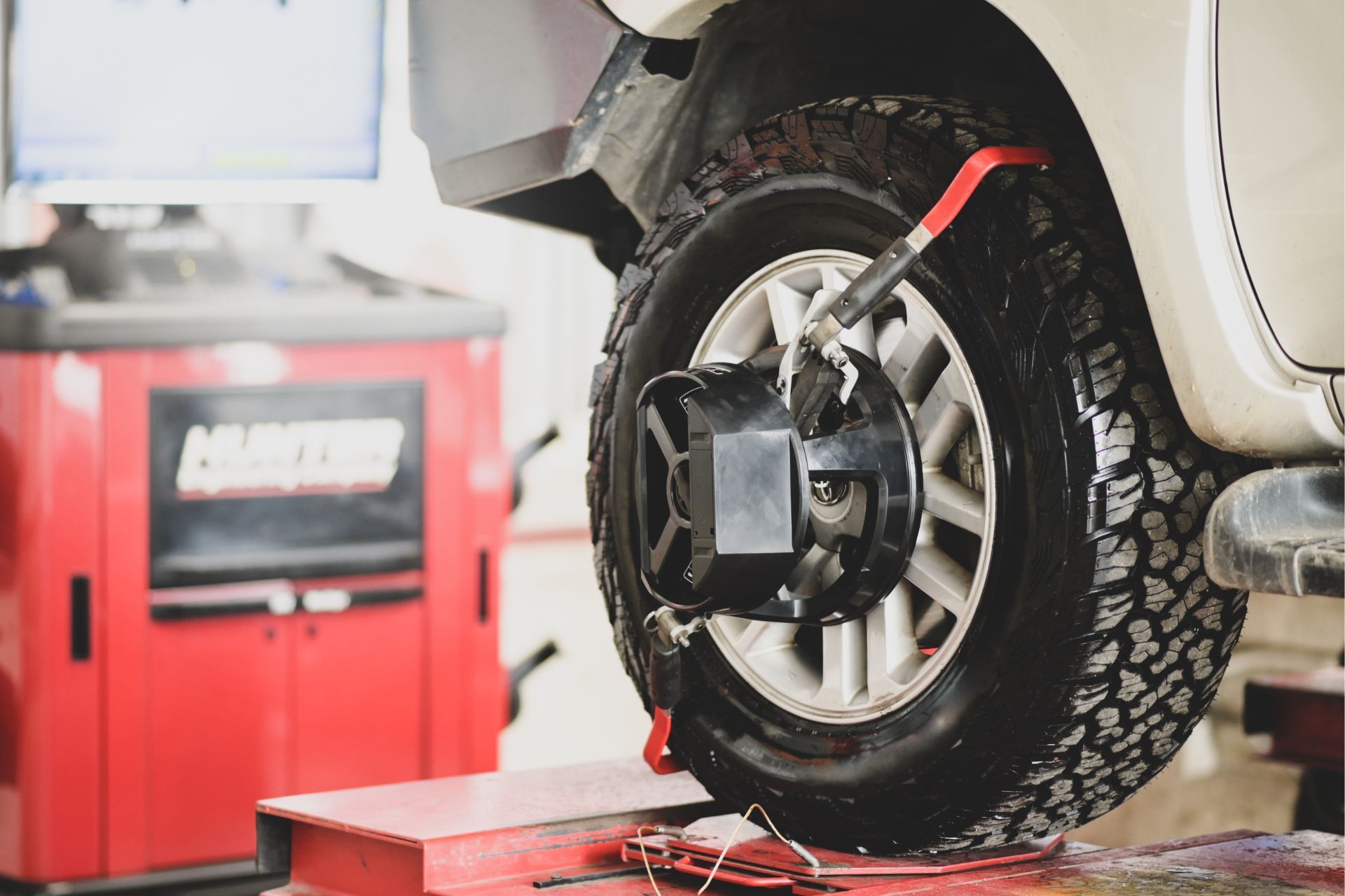 A car is being aligned with a machine in a garage.