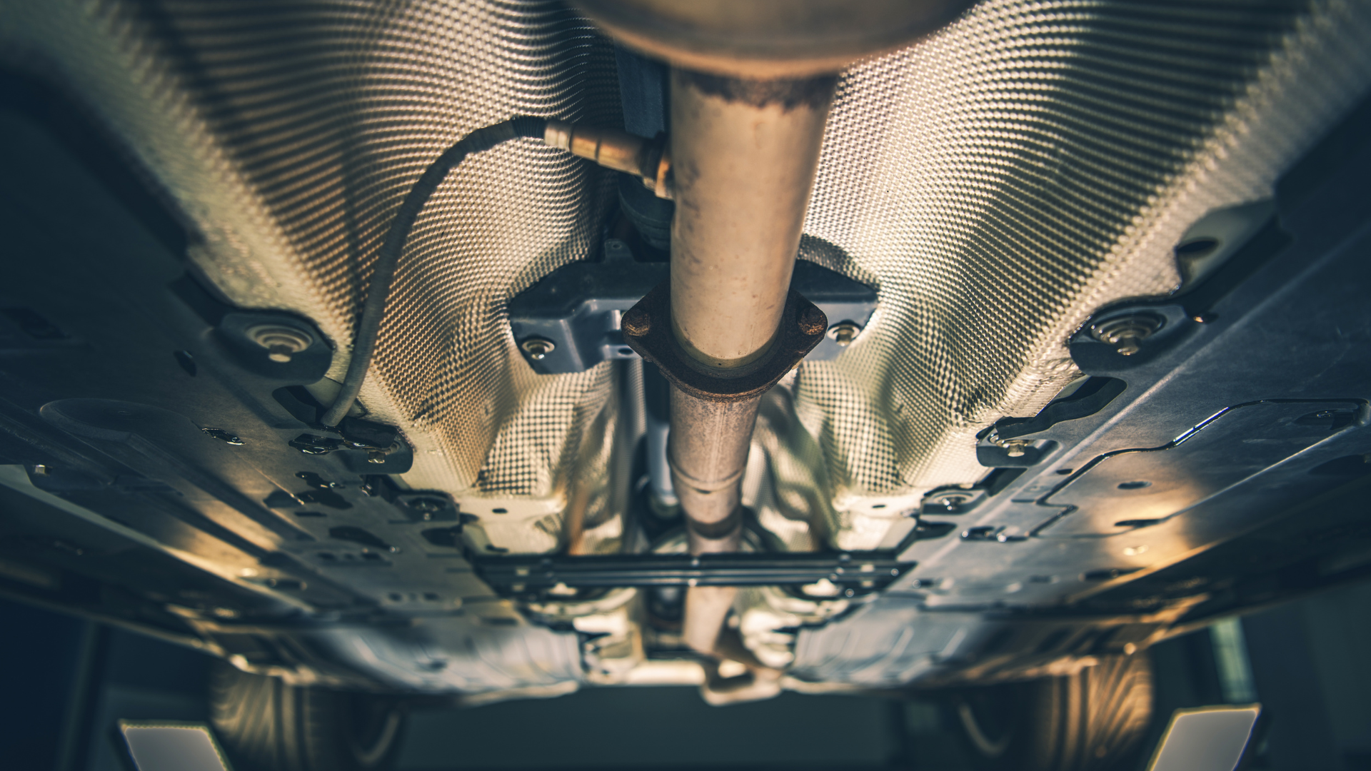 A close up of the underside of a car in a garage.