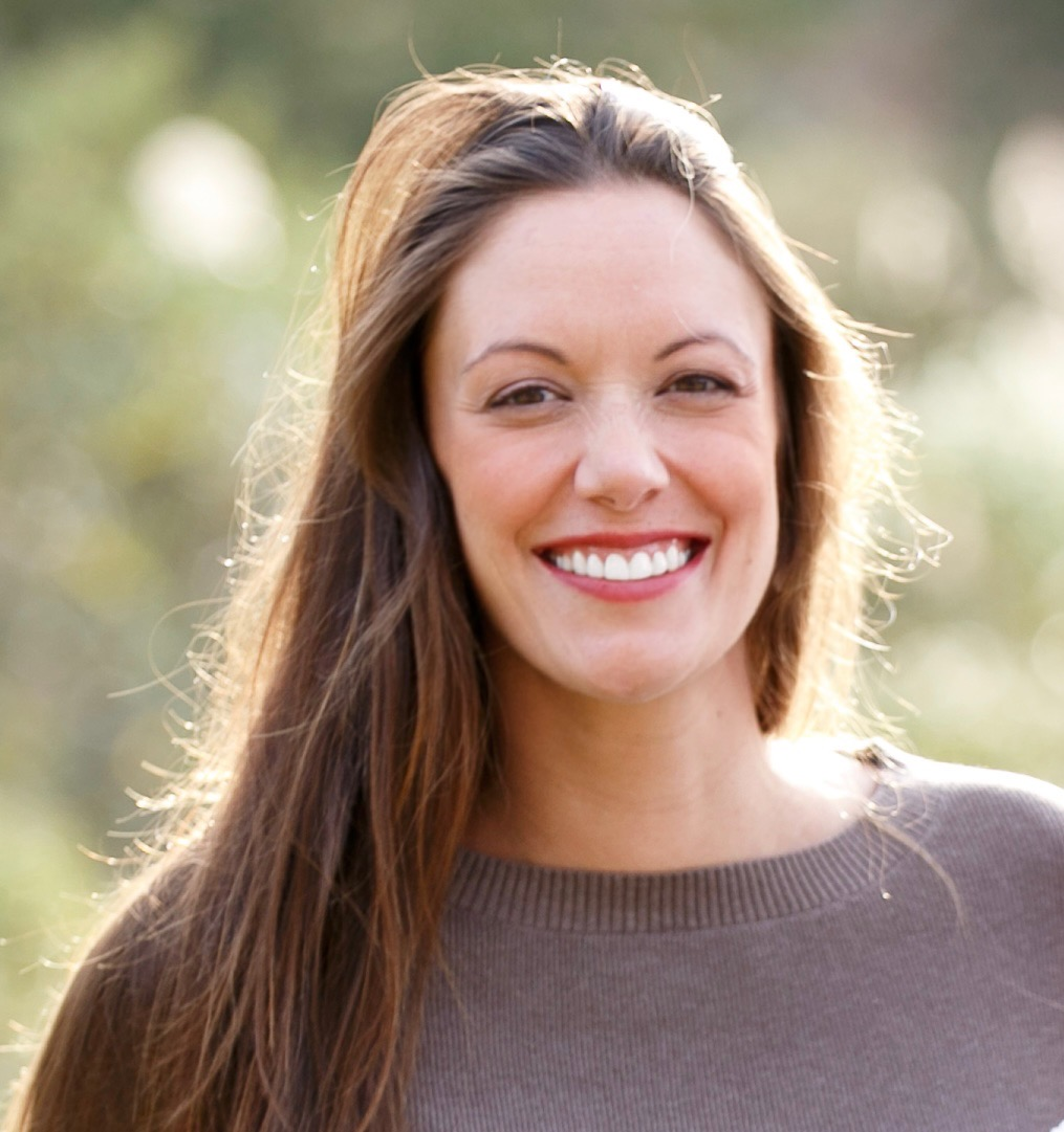 A woman with long hair is smiling for the camera